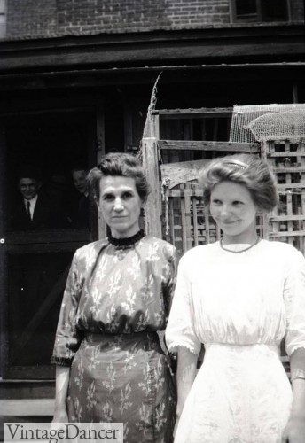 1911, mother and daughter in simple straight line dresses. Middle class.