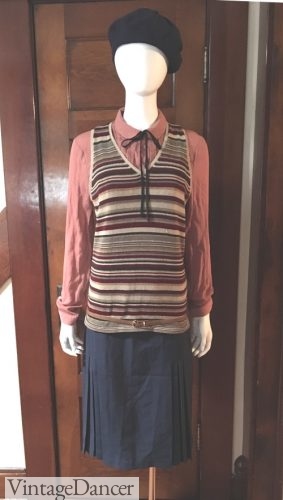 Casual 1920s day outfit combining a pleated skirt, blouse, long knit vest, thin belt, and a knit beret hat. Add a pair of walking oxfords for an easy fashion.