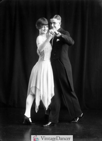 Ropa de baile de los años 20. Esmoquin de corbata blanca (hombre) vestido de baile con dobladillo de pañuelo (mujer)