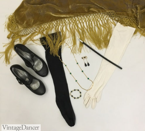 1920s formal accessories: Mary Jane shoes, black stockings, gold fringe shawl, long white gloves, cigarette holder, drop earrings, gold and green bead necklace, green bead and pearl bracelet. More evening 20s ideas VintageDancer.com