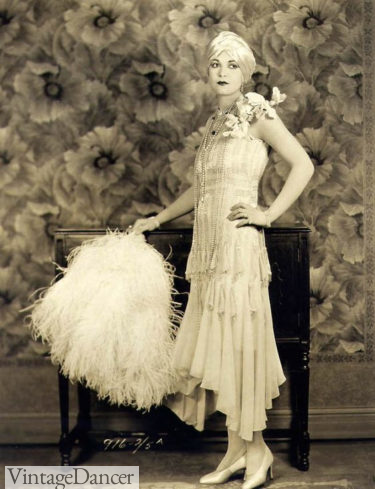 1920s flapper girl. Tiered evening dress with large hand fan