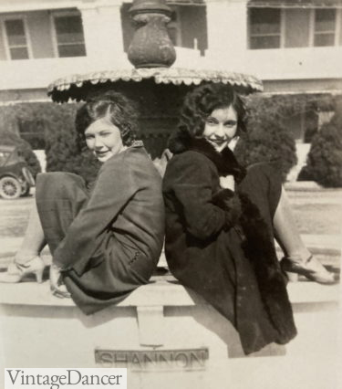 1920s teenage girls sitting by a fountain wearing coats with short bobbed hair