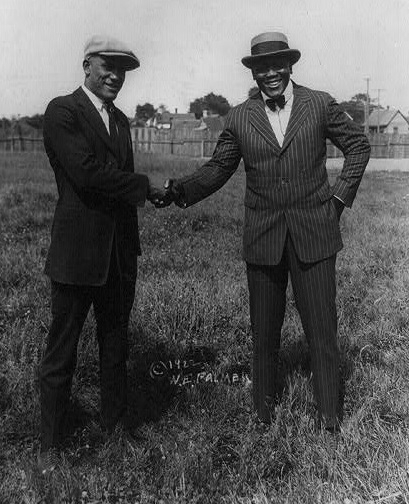 1922 Tut Jackson wearing a striped suit, bow tie and boater hat