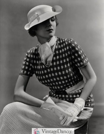 1930s fashion for women: A V neck knit top with a knit scarf tucked under