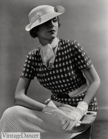 1930s fashion for women: A V neck knit top with a knit scarf tucked under