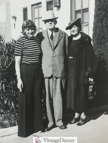 1930s Woman on the left wear a striped ringer T Shirt with wide leg pants, man in suit, woman on right in a two peice dress with coat