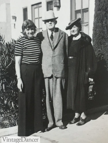  1930s fashion for women 1930s Woman on the left wear a striped ringer T Shirt with wide leg pants, man in suit, woman on right in a two peice dress with coat