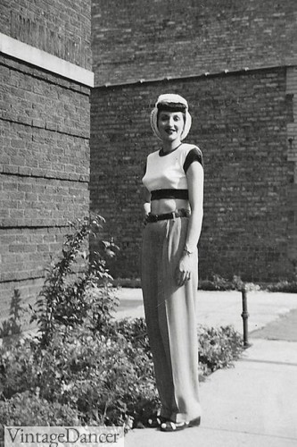 A 1940s look with short sweater top, wide leg pants, snood and sandals. 