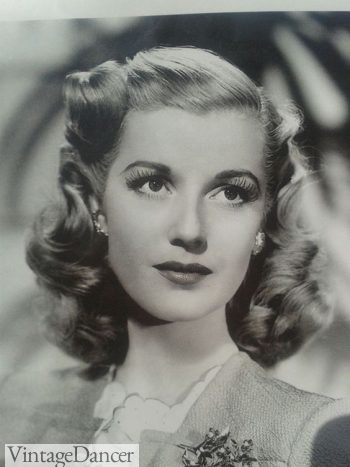 Mid 1940s hairstyle medium length hair with soft curls framing the neck