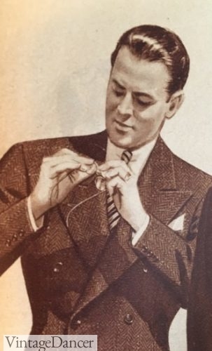 1947 man pulling out his pocket watch attached to the underside of his suit coat