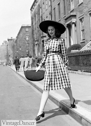 A 1940s look featuring a dark sun hat with matching accessories.