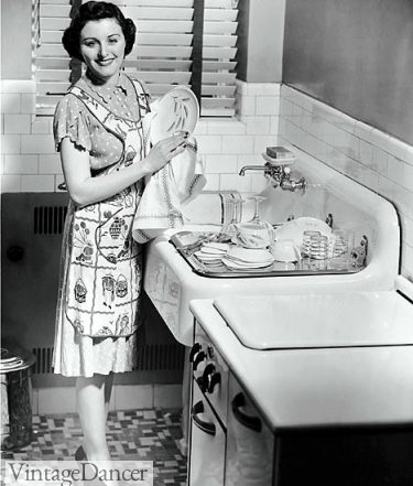 Washing dishes in a full apron 1950s