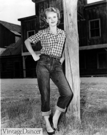 1950s denim jeans western plaid shirt photo Anne Francis demos the western wear influence with plaid shirt and blue jeans. from the 1955 movie Bad Day at the Black Rock