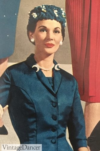 1950s Moon clips and matching earrings decorate the suit collar