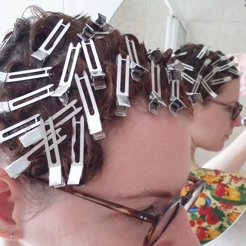 A pin curl set using metal two-pronged curl clips.