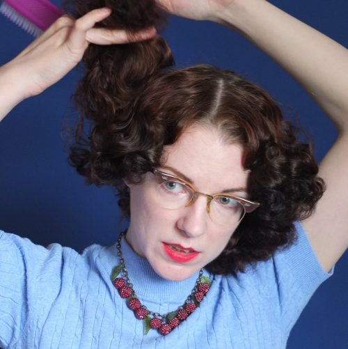 Brushing out a pin curl set is part of the process of shaping the hair into the desired style.