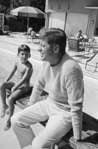 JFK in chinos and Shetland sweater for casual 1960s mens look.