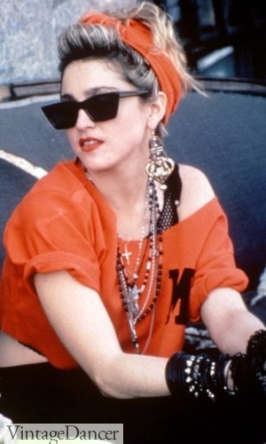 1980s Madonna wearing beaded necklaces and gold dangle earrings