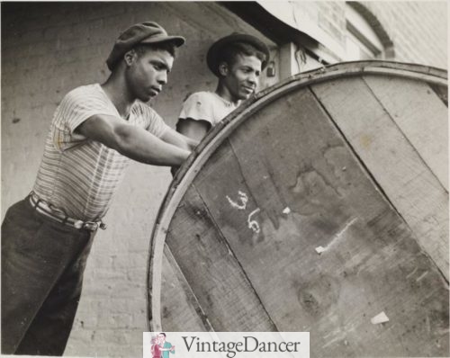 Rolling a Hogshead of Tobacco in Richmond Virginia 1938 wearing a T-shirt. Black men teenager 1930s working