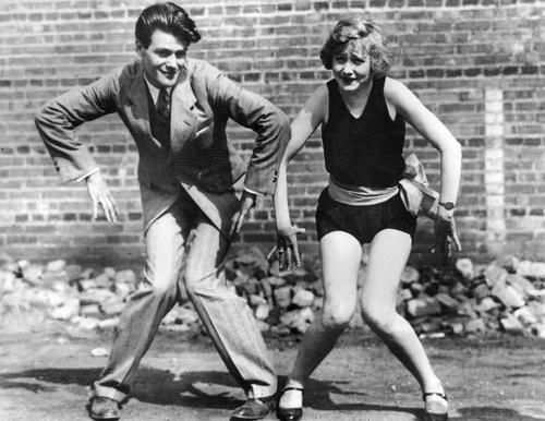 jak tańczyć tańce z lat 20-tych - Taniec w garniturze (mężczyzna) i kostiumie kąpielowym (kobieta) prawdopodobnie na konkurs strojów kąpielowych przy plaży