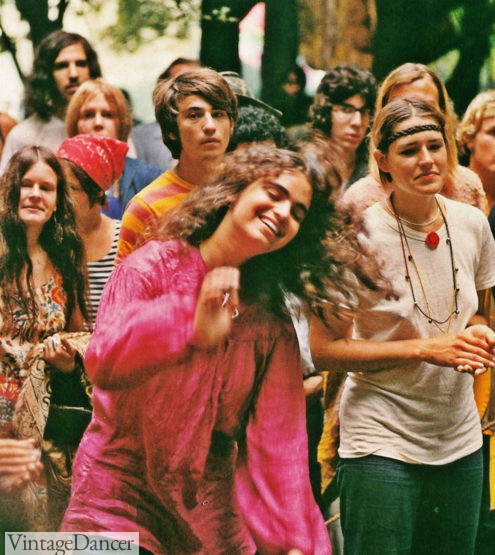 A group of hippie women in various hippie styles pose and smile for the camera at VintageDancer
